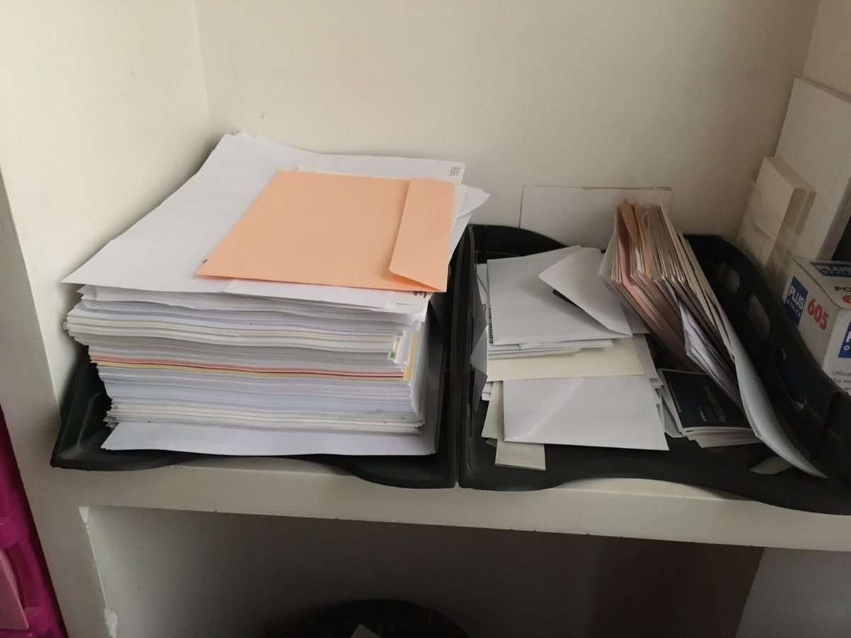 Two office in-trays piled with paper
